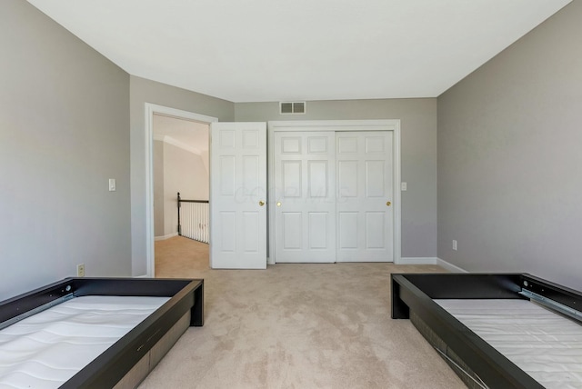 bedroom with visible vents, baseboards, carpet, and a closet