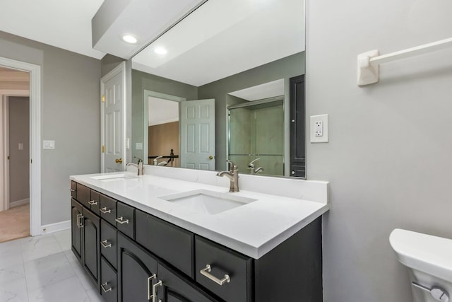 full bath featuring a sink, toilet, marble finish floor, and a shower stall