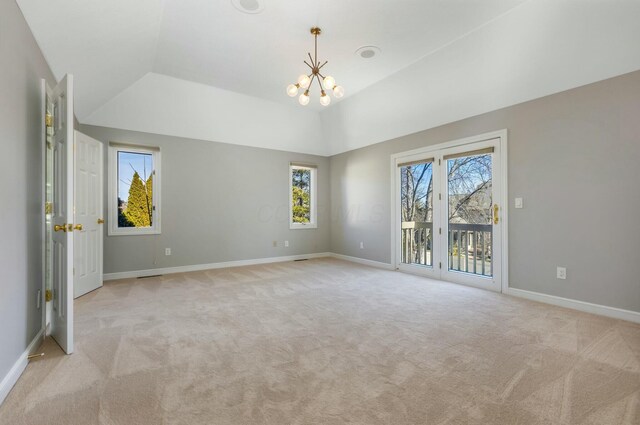 spare room featuring vaulted ceiling, a notable chandelier, baseboards, and light carpet