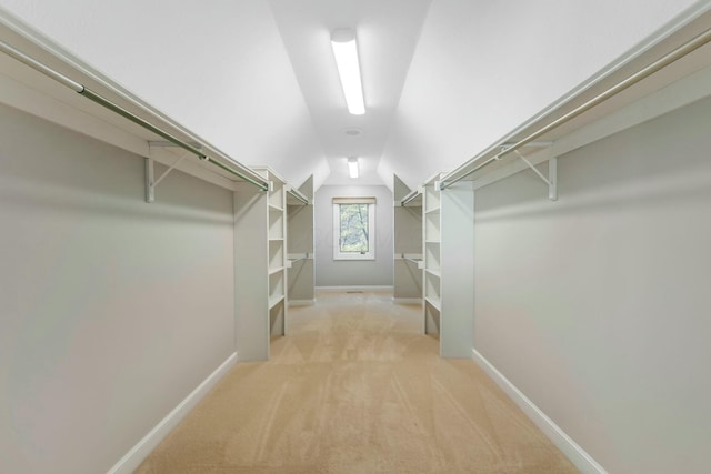 walk in closet featuring lofted ceiling and light colored carpet