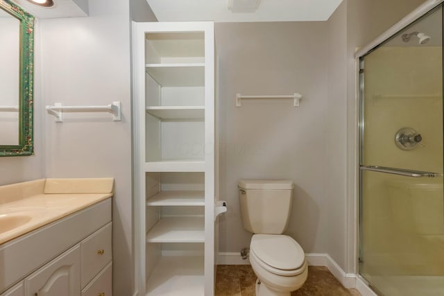 full bath featuring vanity, toilet, baseboards, and a stall shower