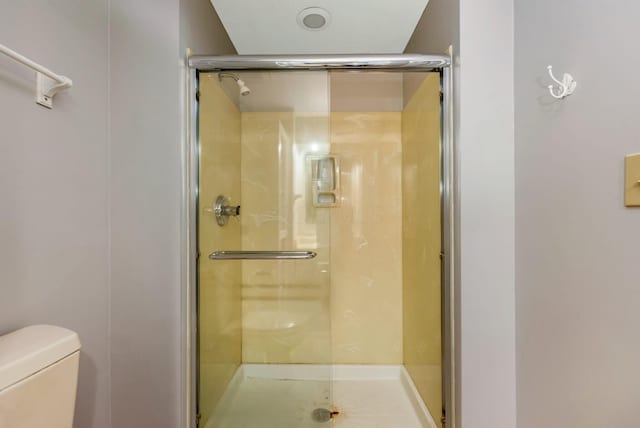 full bath featuring a shower stall and toilet