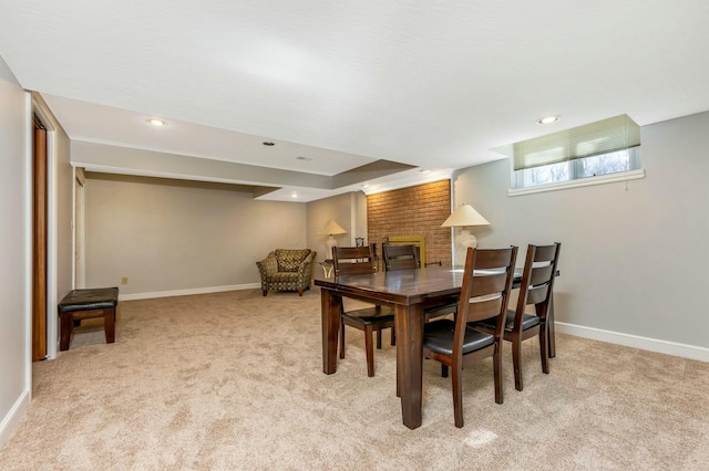 dining space with recessed lighting, light colored carpet, a fireplace, and baseboards