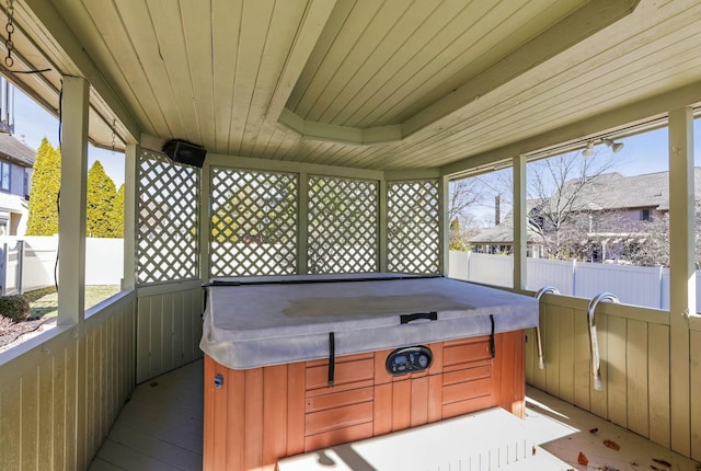 sunroom with a jacuzzi, a healthy amount of sunlight, and wooden ceiling