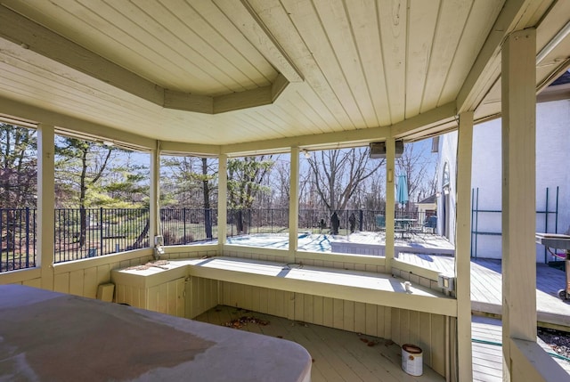 sunroom / solarium featuring a healthy amount of sunlight, wooden ceiling, and a hot tub