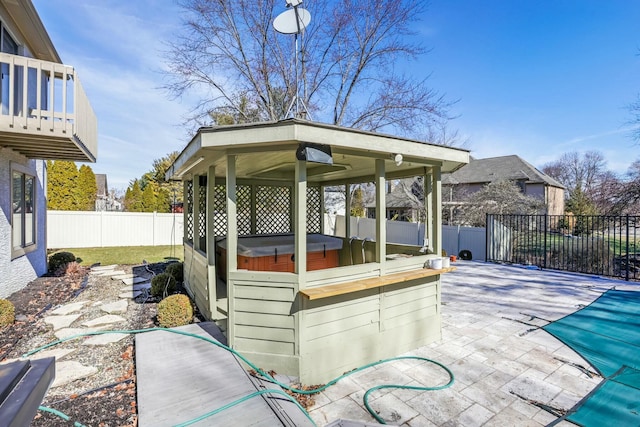 view of patio / terrace with a gazebo, a hot tub, and a fenced backyard