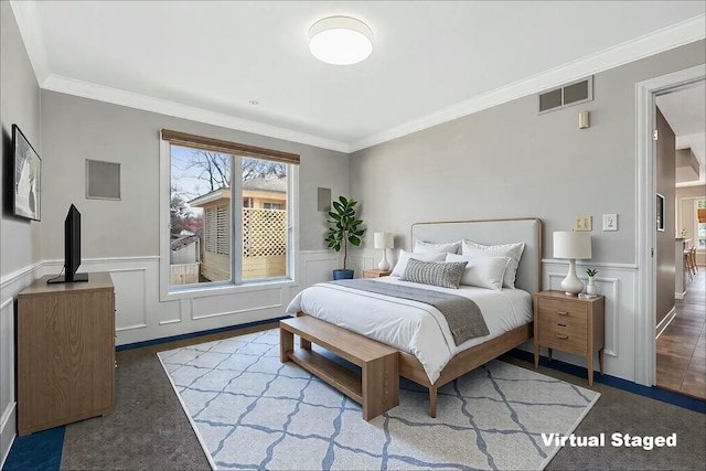 bedroom with visible vents, wainscoting, and crown molding