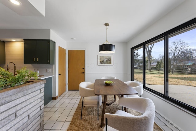 dining area with a baseboard heating unit and light tile patterned floors