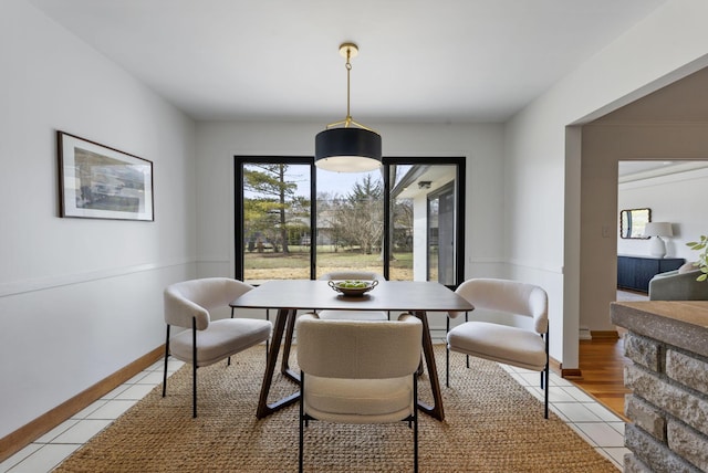 dining space featuring light tile patterned floors and baseboards