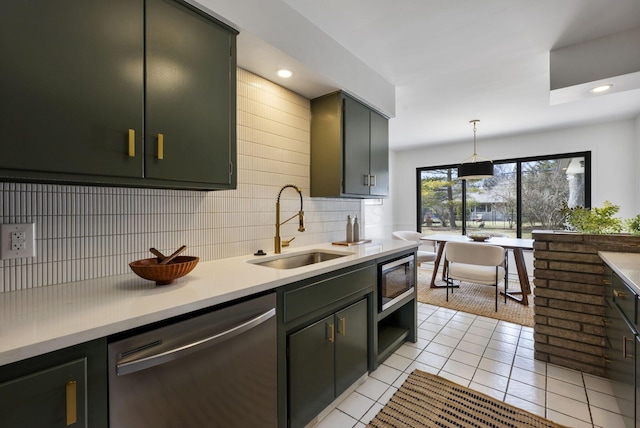 kitchen with light tile patterned floors, light countertops, backsplash, appliances with stainless steel finishes, and a sink