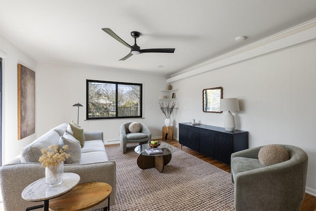 living room with wood finished floors, a ceiling fan, and crown molding