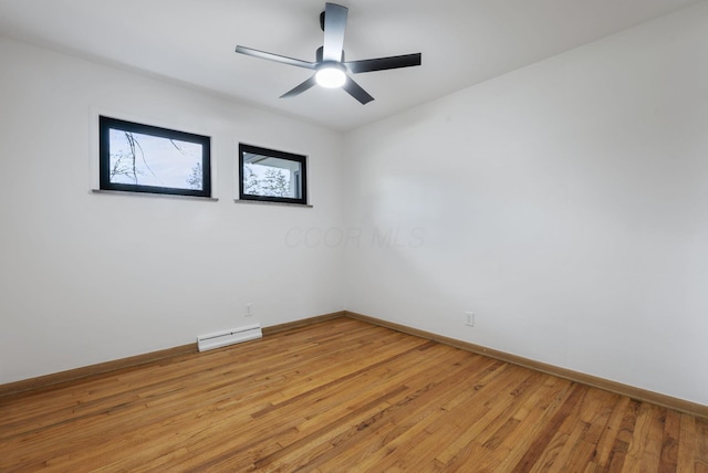 spare room featuring light wood-style floors, a baseboard radiator, baseboards, and a ceiling fan