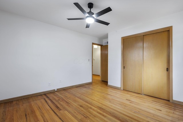 unfurnished bedroom featuring ceiling fan, a closet, light wood-type flooring, and baseboards