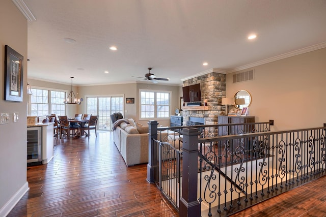 living room with beverage cooler, visible vents, crown molding, and hardwood / wood-style flooring