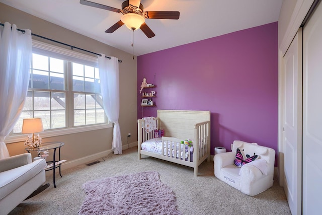bedroom with baseboards, visible vents, ceiling fan, carpet flooring, and a closet