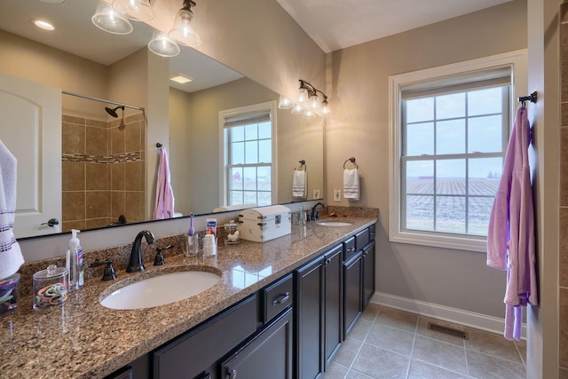bathroom featuring plenty of natural light, a sink, baseboards, and tile patterned floors