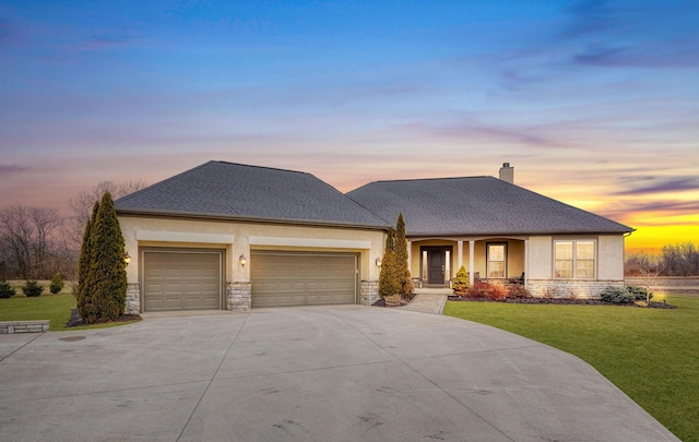 view of front of home featuring stucco siding, concrete driveway, an attached garage, a front yard, and stone siding