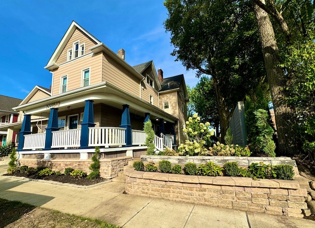 view of front of property featuring covered porch and a chimney