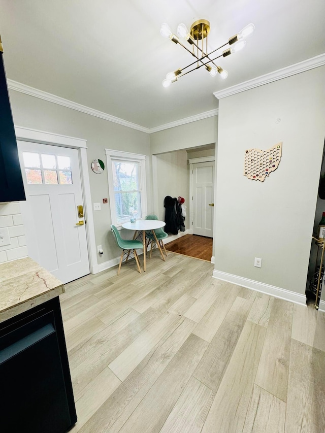 interior space with crown molding, light wood finished floors, baseboards, and an inviting chandelier