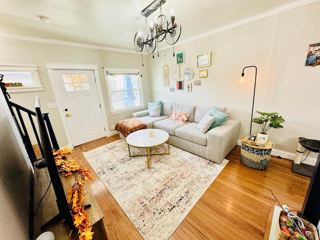 living area featuring a chandelier, ornamental molding, wood finished floors, and baseboards