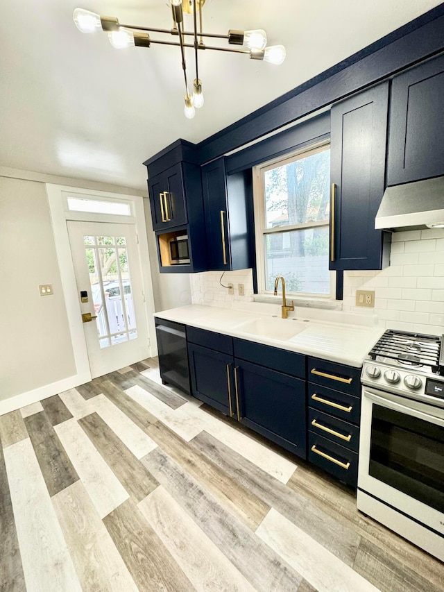 kitchen featuring decorative backsplash, dishwasher, gas range, premium range hood, and a sink