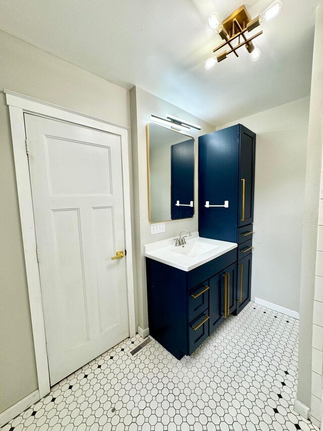 bathroom featuring tile patterned floors, baseboards, visible vents, and vanity