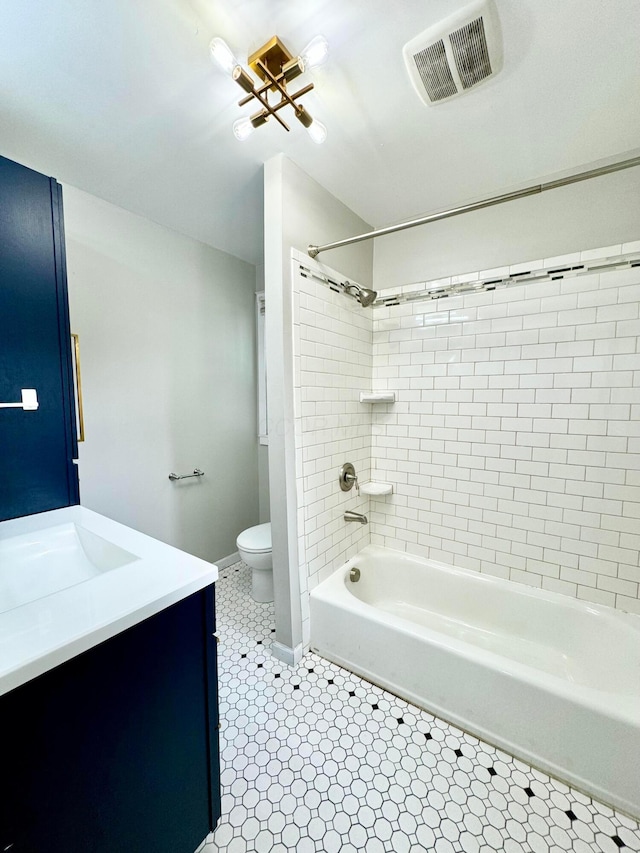 full bathroom with toilet, vanity, visible vents, baseboards, and shower / washtub combination