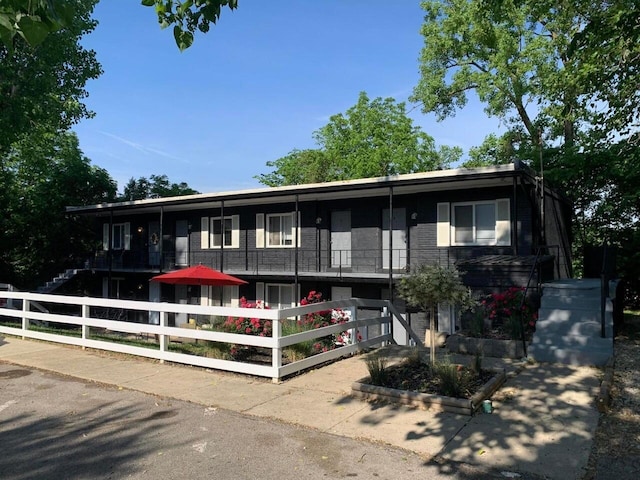 view of front facade with fence and brick siding