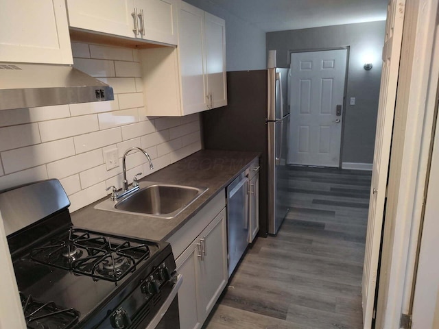 74 W Moler St, Columbus, OH 43207 - kitchen featuring stainless steel appliances, tasteful backsplash, a sink, wood finished floors, and under cabinet range hood