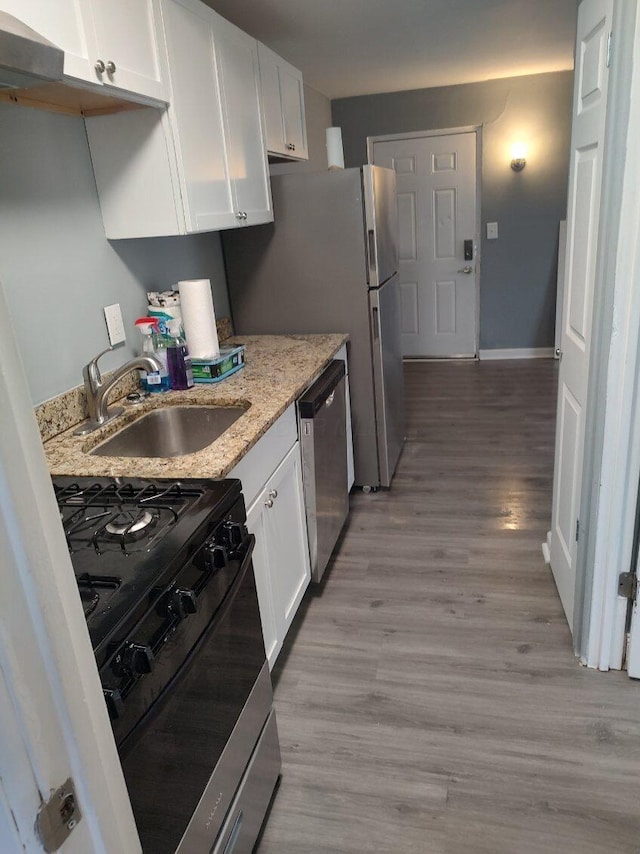 74 W Moler St, Columbus, OH 43207 - kitchen with range with gas cooktop, stainless steel dishwasher, white cabinetry, a sink, and light wood-type flooring