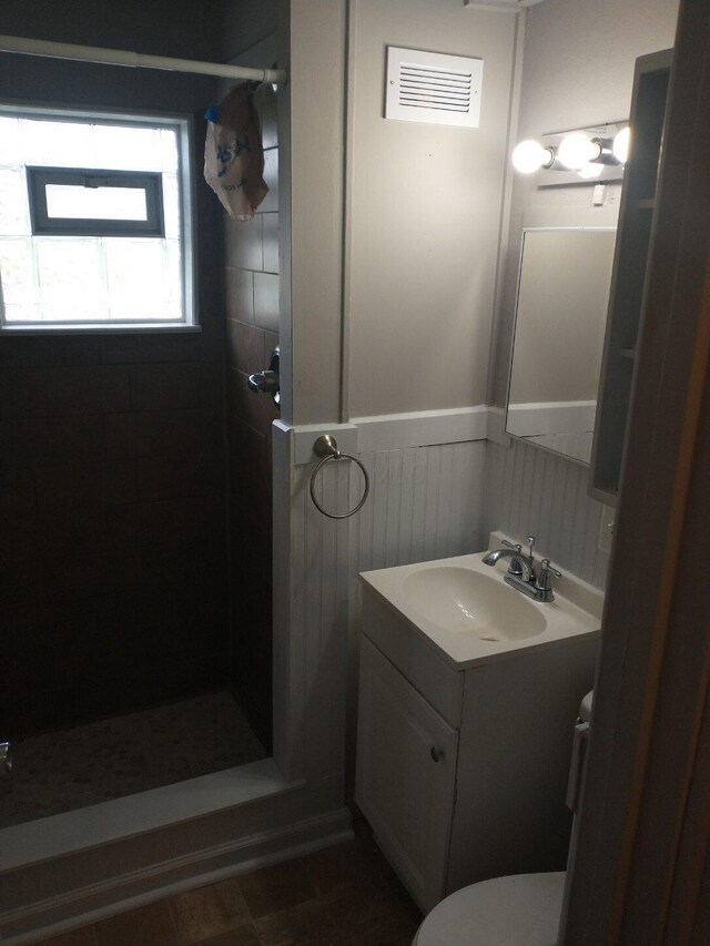 74 W Moler St, Columbus, OH 43207 - full bathroom with a stall shower, visible vents, wainscoting, toilet, and vanity