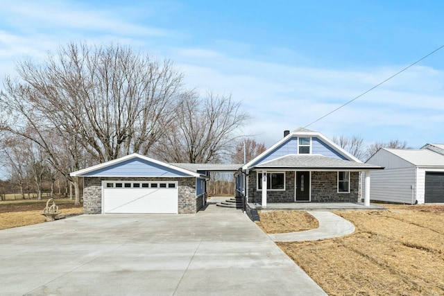 view of front of home featuring a porch, concrete driveway, a garage, and stone siding