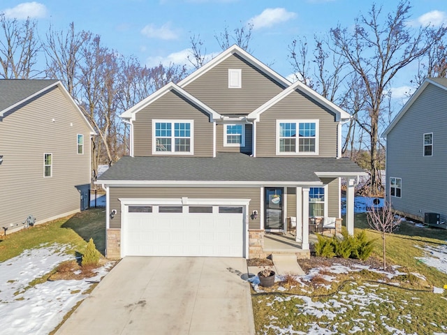 traditional-style house with a porch, central AC unit, a garage, stone siding, and driveway