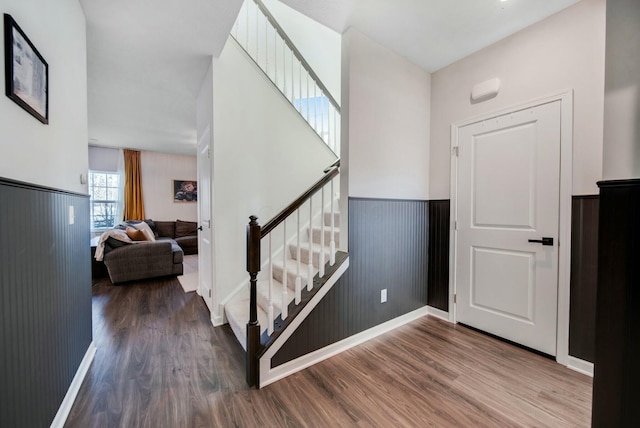 staircase featuring a wainscoted wall and wood finished floors