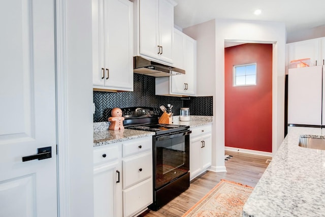 kitchen featuring under cabinet range hood, white cabinets, light wood-style floors, black electric range, and freestanding refrigerator