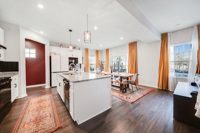 kitchen with dark wood-type flooring, a sink, stainless steel dishwasher, and light stone countertops