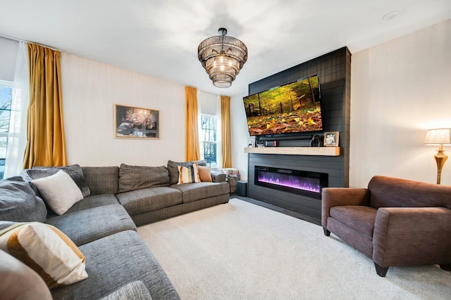 living area with a glass covered fireplace and a notable chandelier