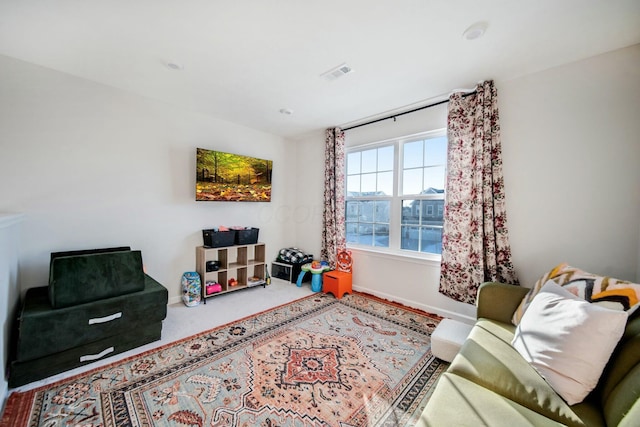 sitting room with carpet floors, baseboards, and visible vents