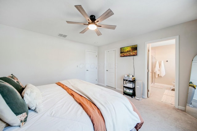 bedroom featuring ensuite bathroom, light carpet, a ceiling fan, visible vents, and baseboards