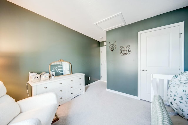 living area with light carpet, attic access, and baseboards