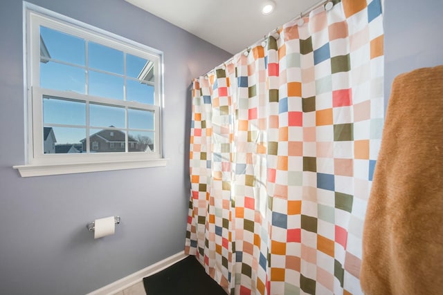 bathroom with a shower with curtain and baseboards