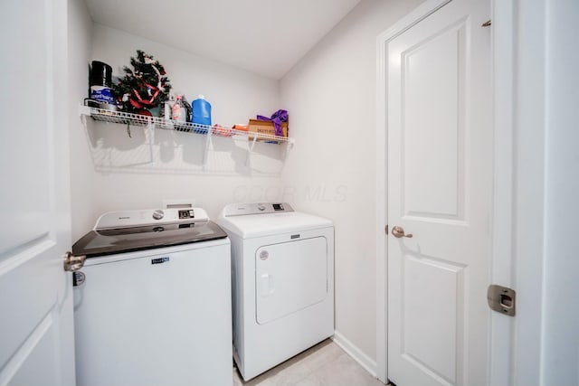 laundry area with washing machine and dryer, laundry area, and light tile patterned floors