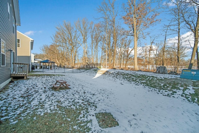 yard covered in snow featuring fence