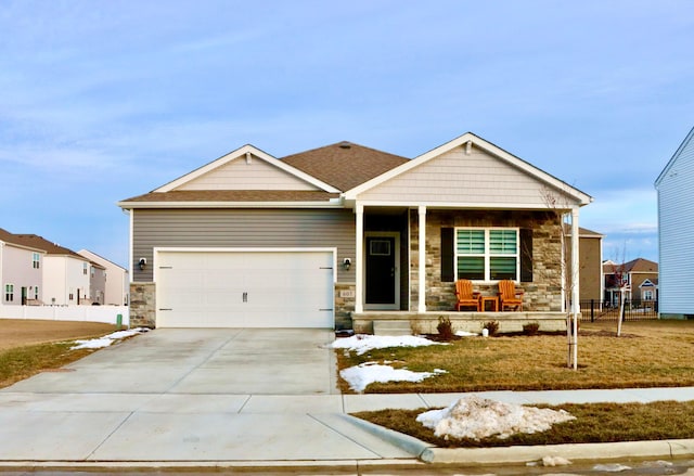 view of front of home featuring a porch, concrete driveway, stone siding, and a garage