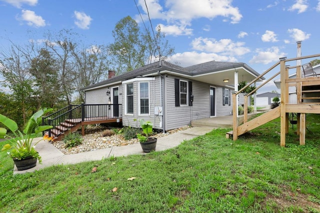 exterior space featuring a chimney, stairway, a deck, and a yard