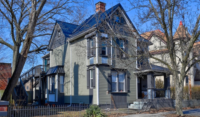 view of property exterior featuring a fenced front yard and a chimney