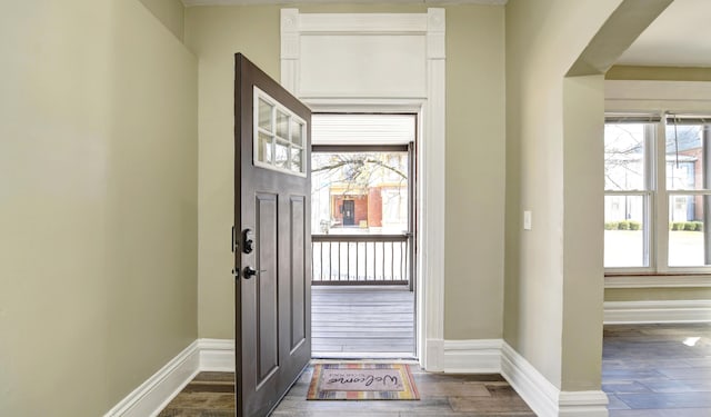 foyer entrance with dark wood-style floors and baseboards