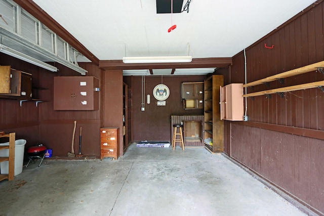 garage with a garage door opener and wooden walls