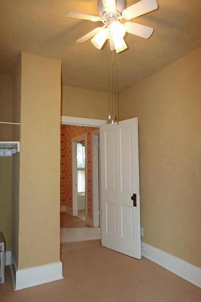 empty room with ceiling fan, carpet flooring, and baseboards