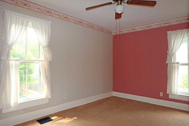 empty room featuring carpet flooring, baseboards, and wallpapered walls